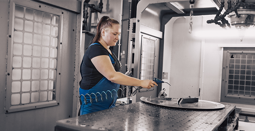 Eine moderne CNC-Maschine mit Bedienfeld und Bildschirm in einer Produktionshalle.
